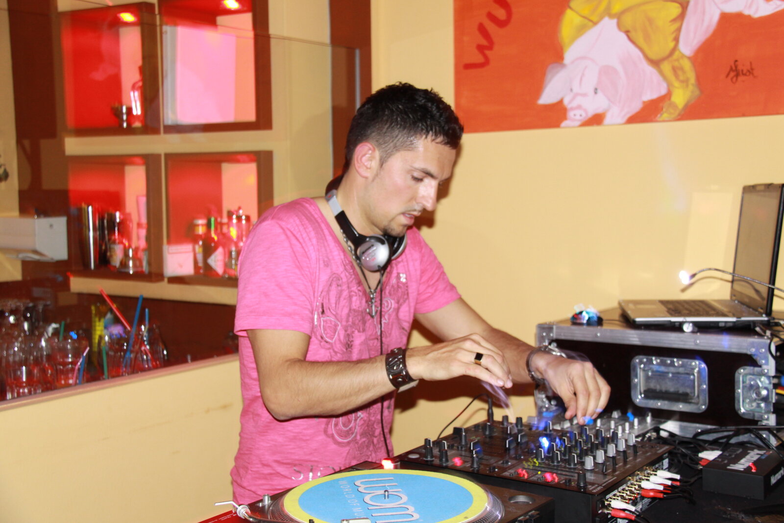 DJ Marseille en t-shirt rose mixant sur platines vinyle en lounge