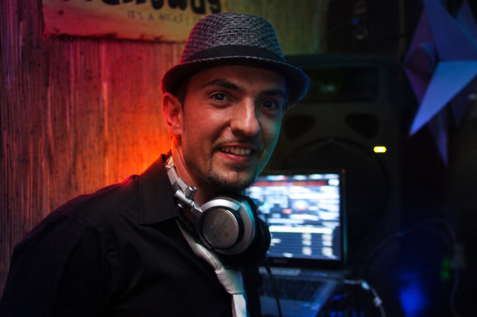 DJ Marseille avec chapeau fedora et casque audio en club